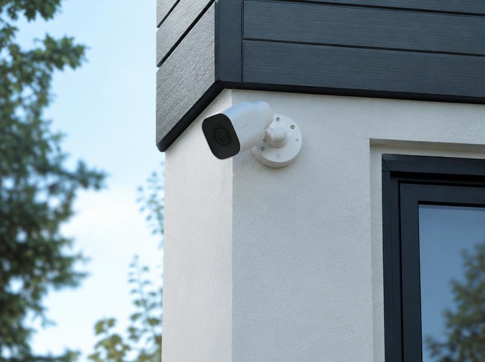 White security camera installed on the corner of a modern home